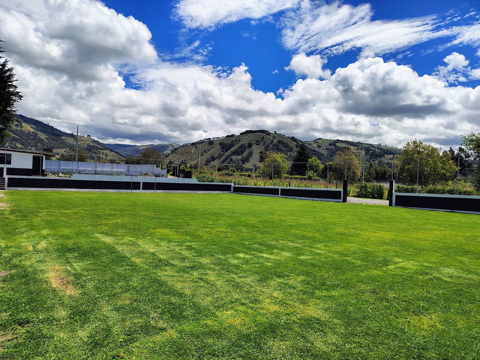 Cancha de césped y montañas